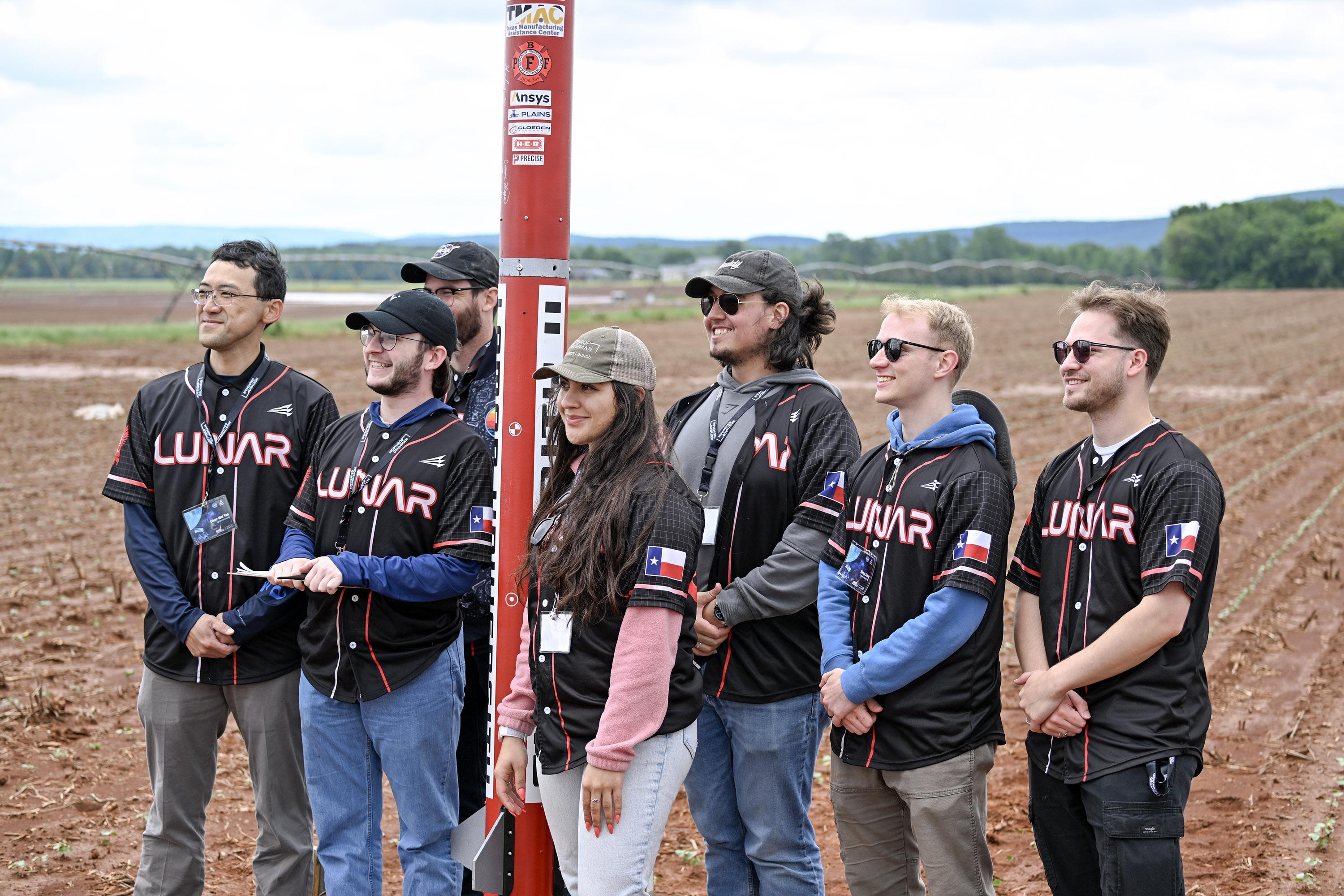 LUNAR members preparing beside their rocket at a launch field.