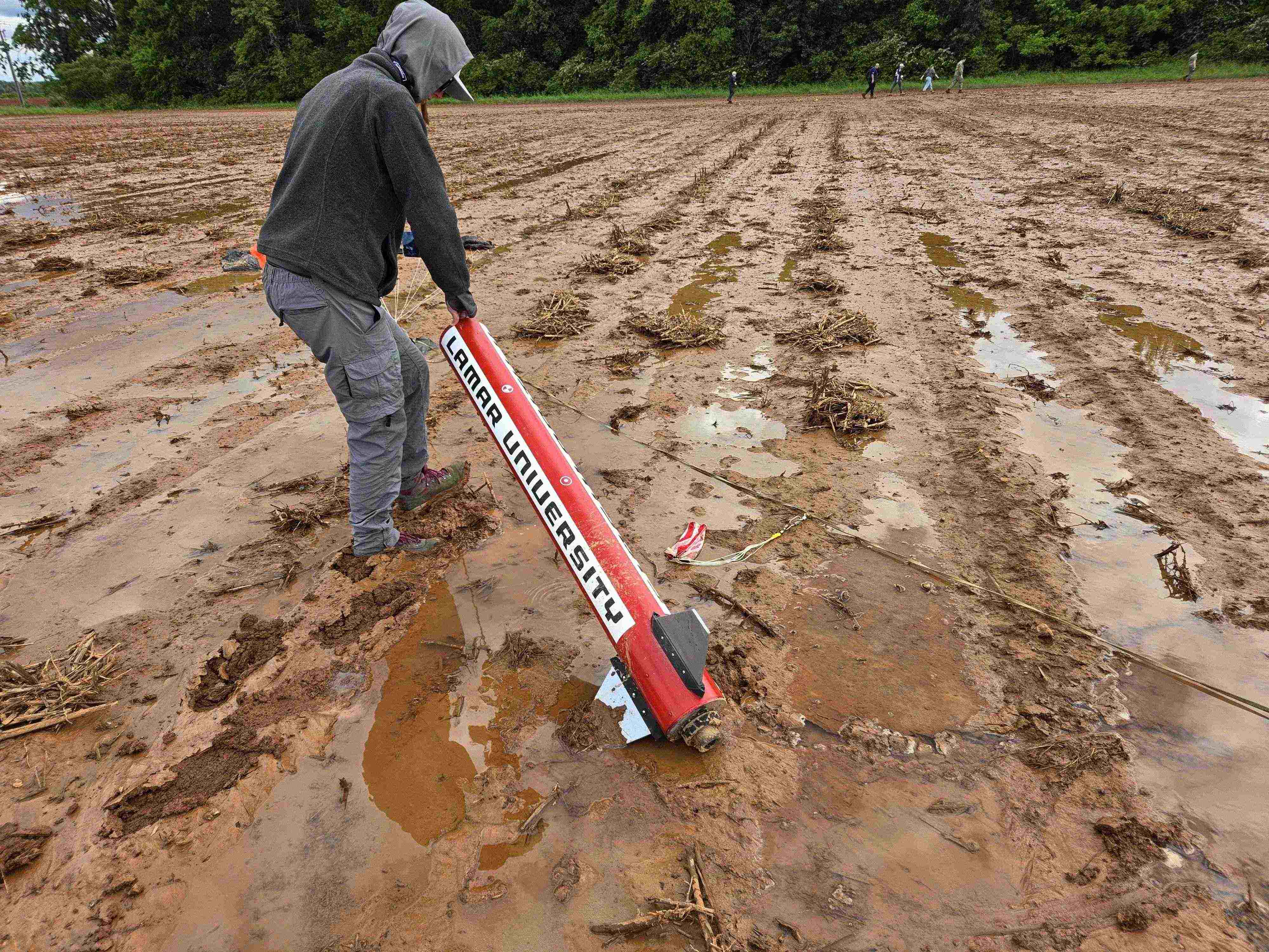 A LUNAR member carrying a rocket across a wet test field.