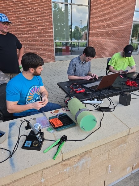 LUNAR members working with electronics and ground equipment outdoors.